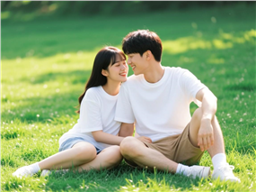 坐在草地上的一对年轻情侣图片